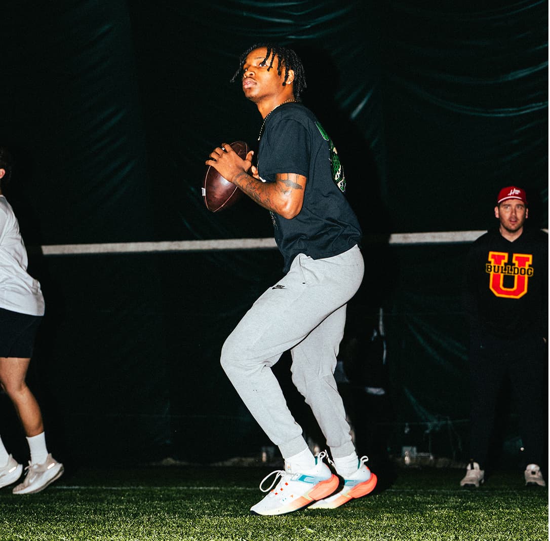 Three quarterbacks at QB Era are dropping back together during a drill looking downfield at potential receivers